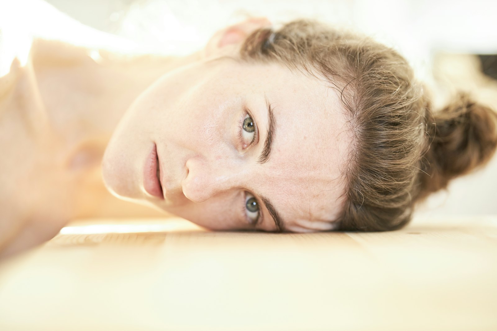 A woman lying down, relaxed, eyes gently closed